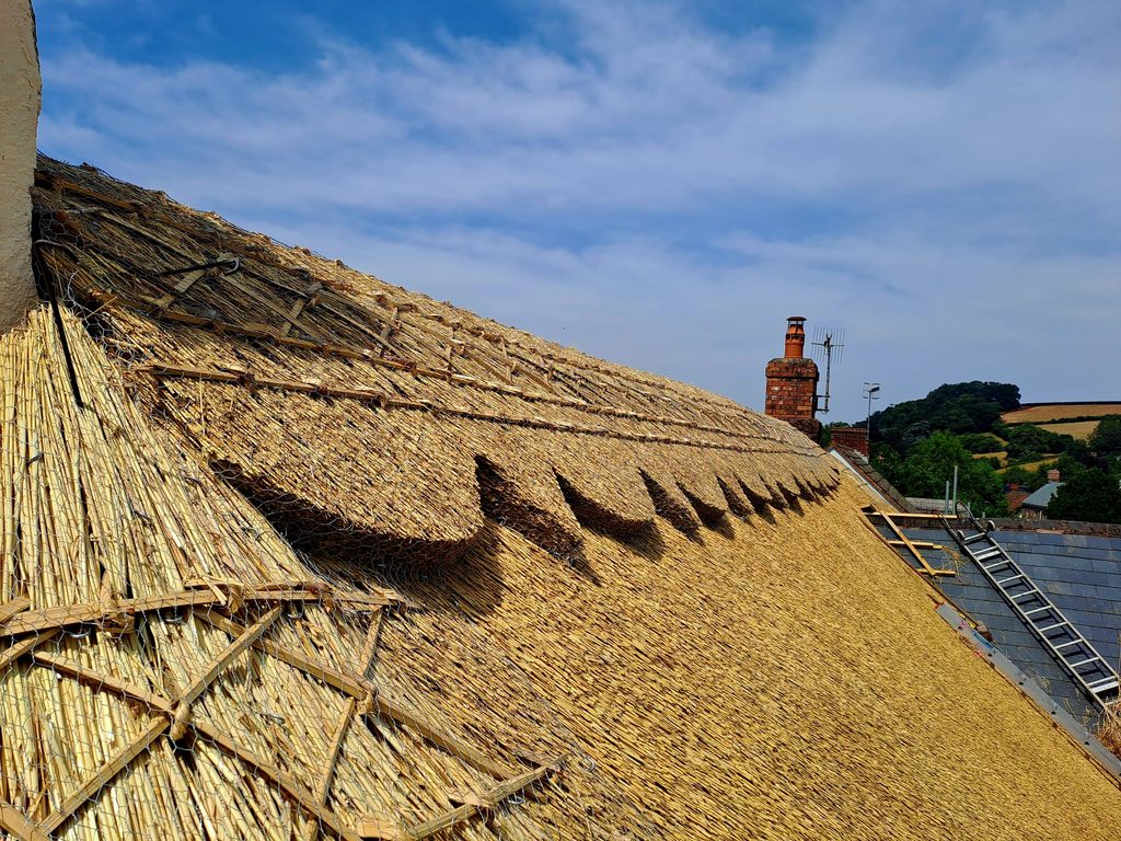 Details on a decorative block cut pattern ridge on a thatched house in Somerset